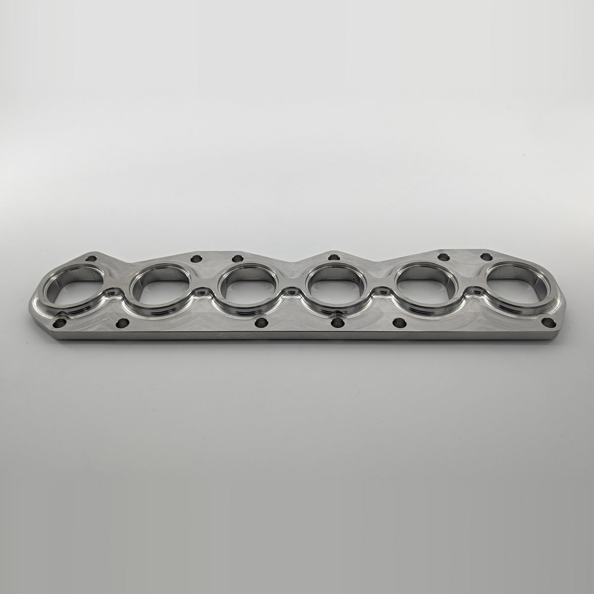 VR6 3.6L 24V exhaust manifold flange small port, tube side angled view showing recessed tube pockets and 16mm thickness, 304L stainless